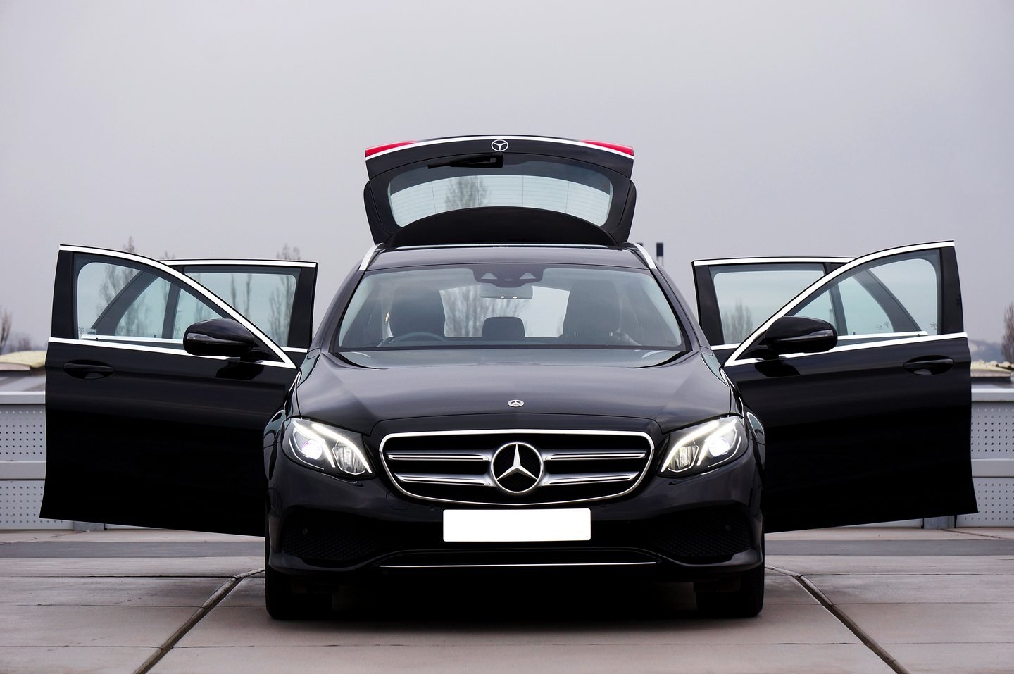 Black Mercedes-Benz E-Class with all doors and the boot open — an example of the premium category