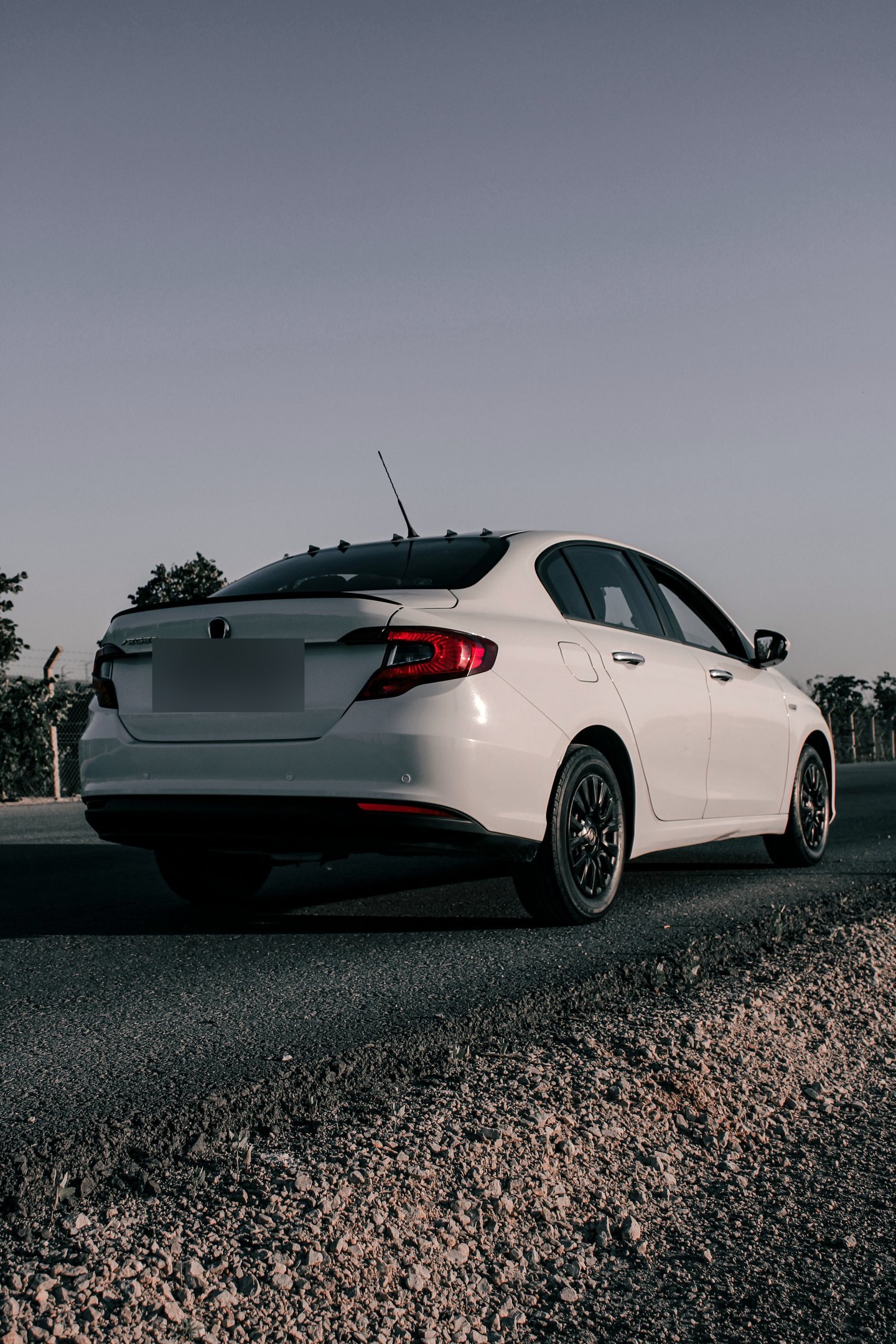 White sedan on an open road at twilight — an example of the sedan category